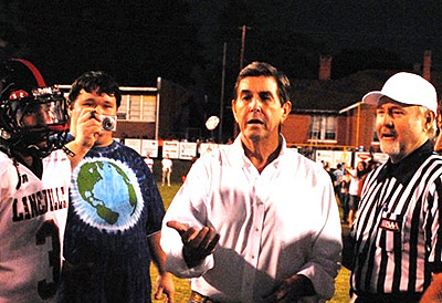 Former Gov. Bob Riley, a graduate of Clay County High School, tosses a commemorative coin at midfield prior the final Clay Bowl game between Lineville and his alma mater. Clay County won the 101st meeting 7-6. (Photo special to AHSAA)